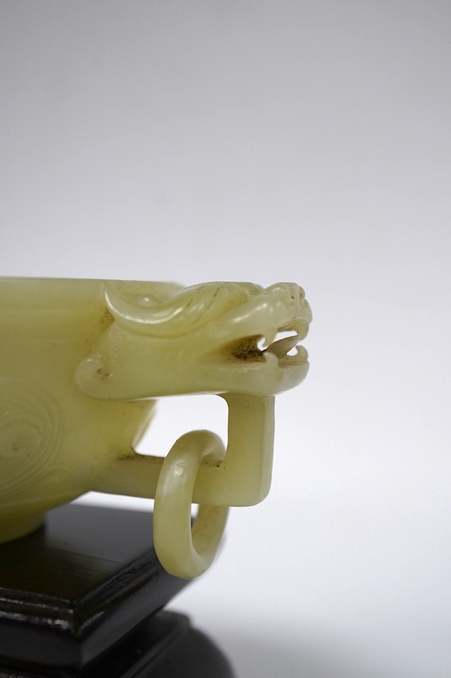 A Chinese archaistic pale green bowenite jade twin handled cup on stand, cup 11.5cm wide. Condition - cup good, stand good